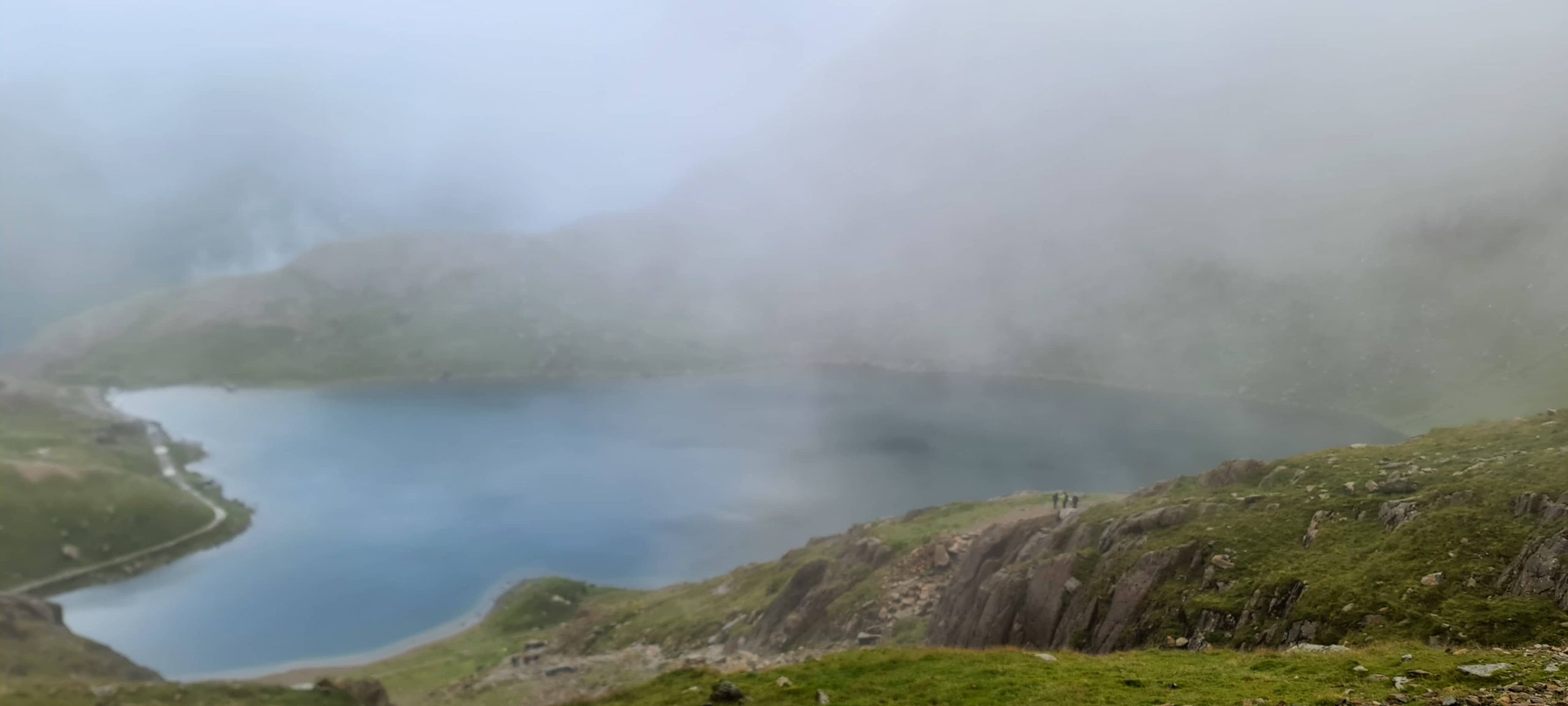 Fog over a lake on a hike up Pyg track up Snowden in Wales